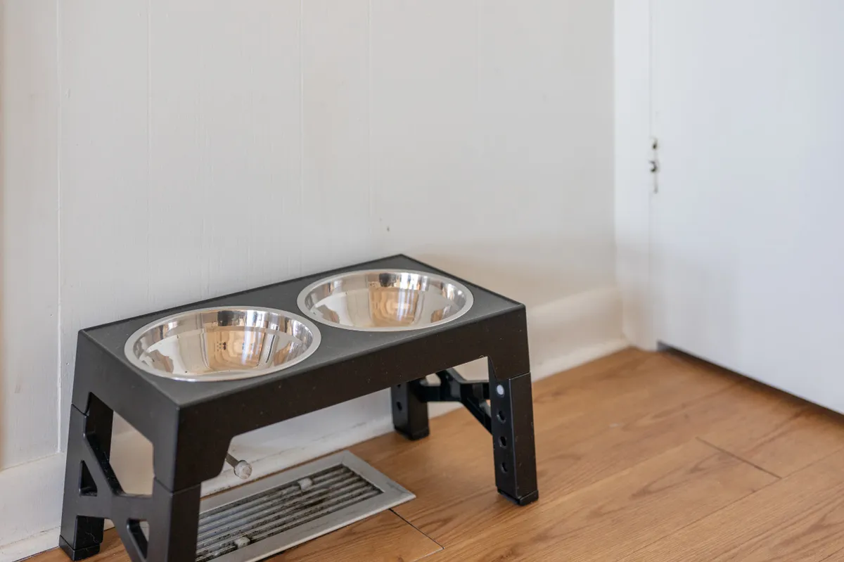 A cozy indoor nook featuring pet food and water bowls placed near a door, subtly emphasizing the home’s pet-friendly amenities and thoughtful touches for four-legged guests.